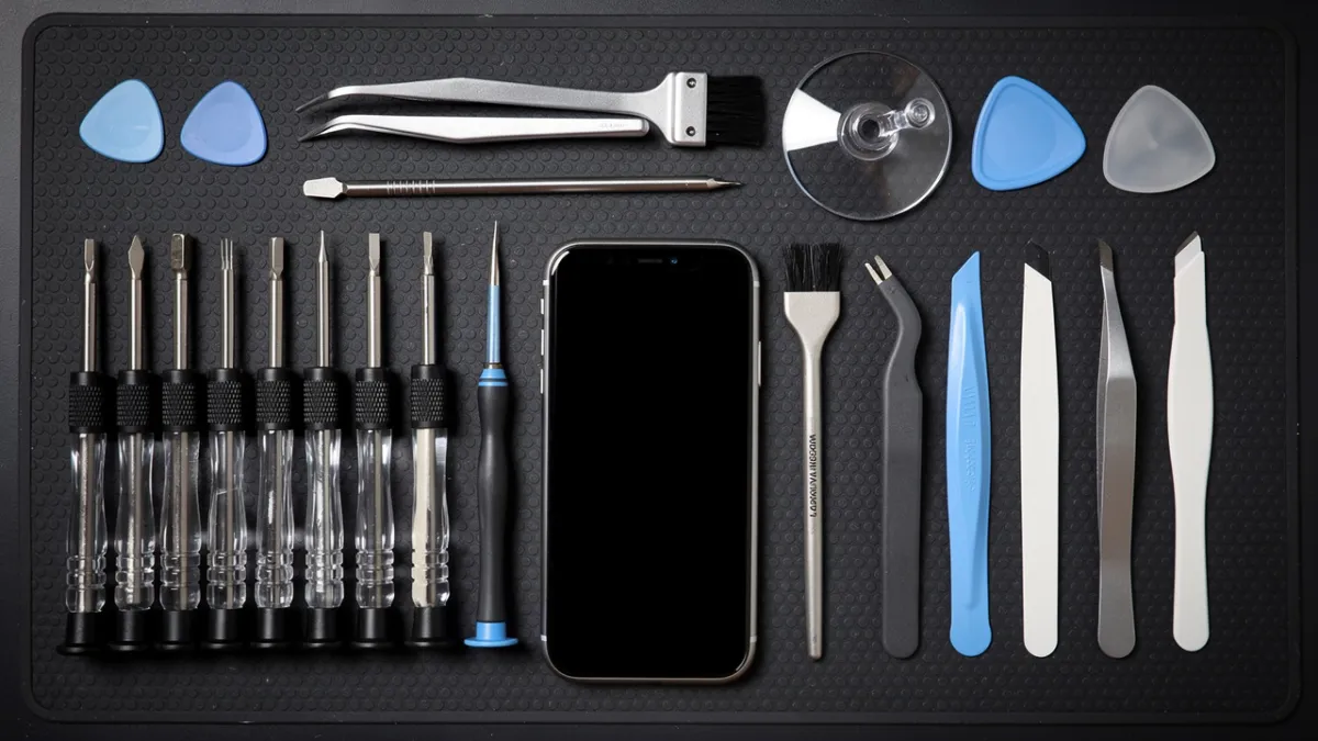 Kit de ferramentas para manutenção de celular sobre bancada de assistência técnica